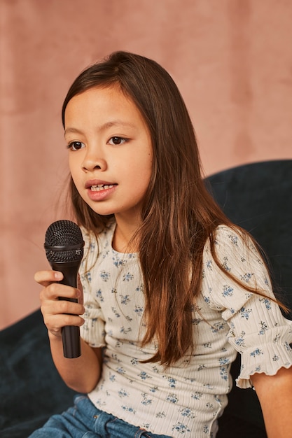 Young girl learning how to sing at home