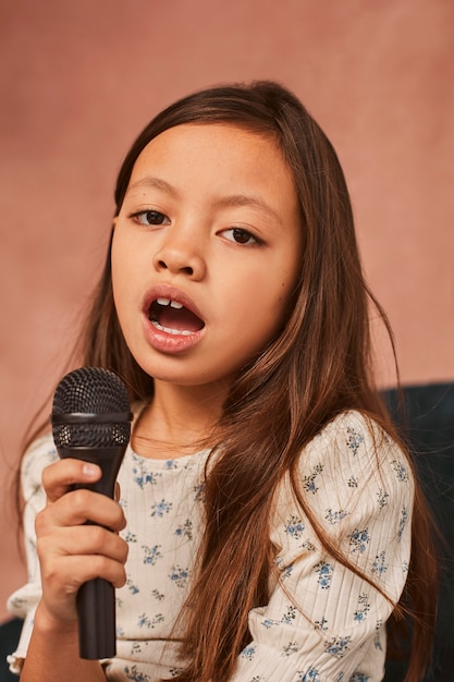 집에서 노래하는 방법을 배우는 어린 소녀