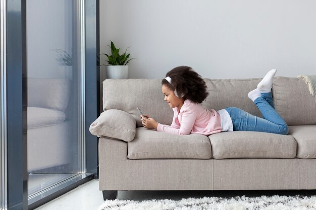 Young girl listening to music on the couch