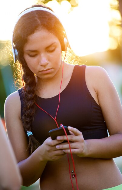 携帯電話で音楽を聴いている少女。