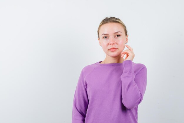 白い背景の上のカメラを見ている若い女の子