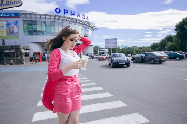 Young girl looking at her chocolate milkshake on the street