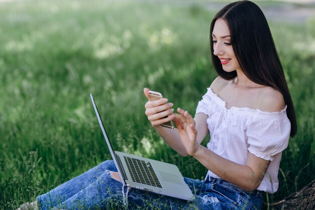 笑みを浮かべながら、若い女の子は彼女のスマートフォンを見