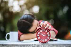 Free photo young girl lying down on desk after reading book