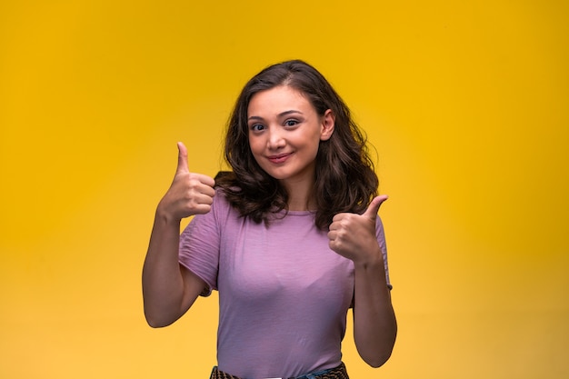 Young girl makes good signs by thumbs up. 