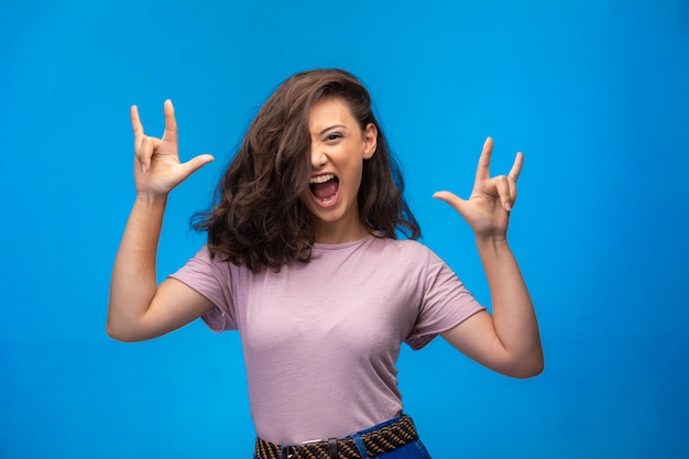 Young girl making peace symbol with fingers and crazy screaming. 