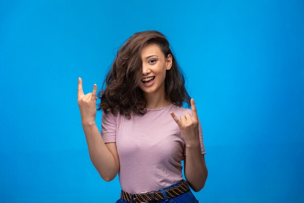 Young girl making peace symbol with fingers and having fun. 