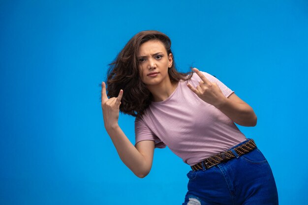 Young girl making peace symbol with fingers and thinks negative.