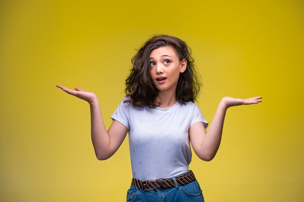 Young girl making stupid face with open hands.