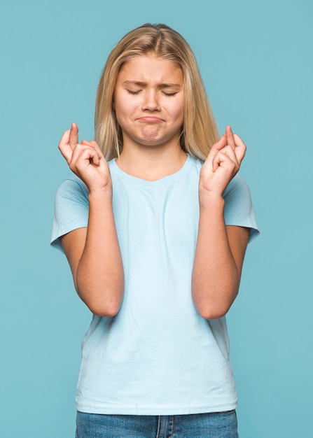 Foto gratuita ragazza che fa desiderio con fondo blu