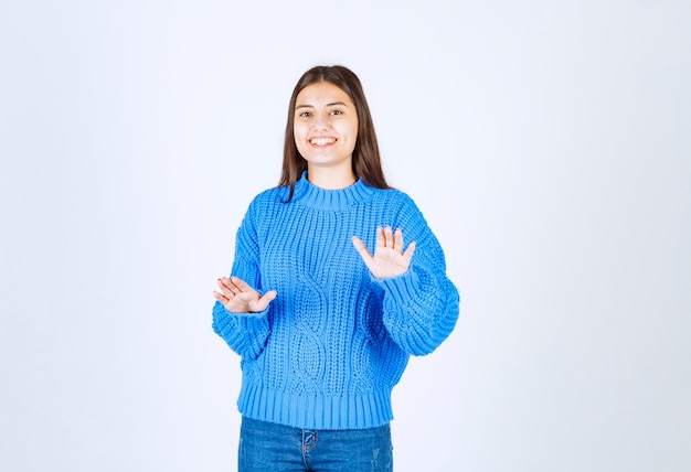 파란색 스웨터 서 고 흰색 회색에 포즈에 어린 소녀 모델.