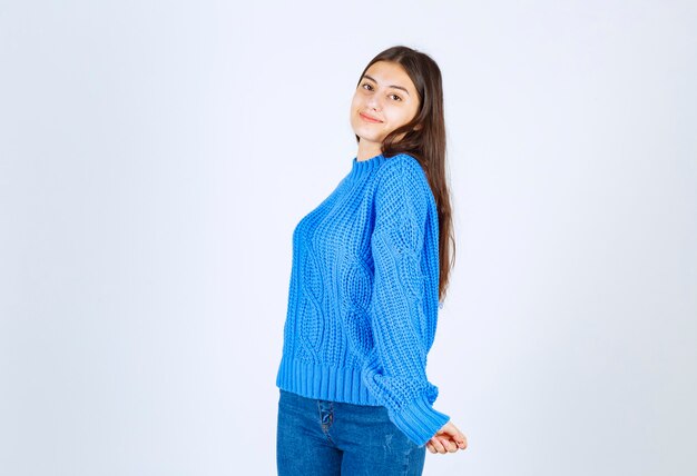 young girl model in blue sweater standing and posing on white-gray .