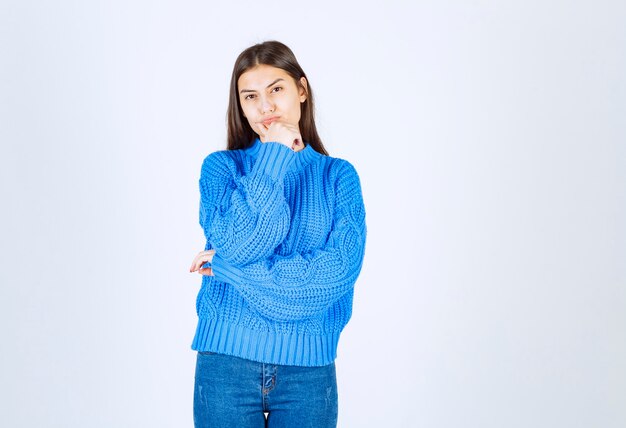 young girl model in blue sweater standing and posing on white-gray .