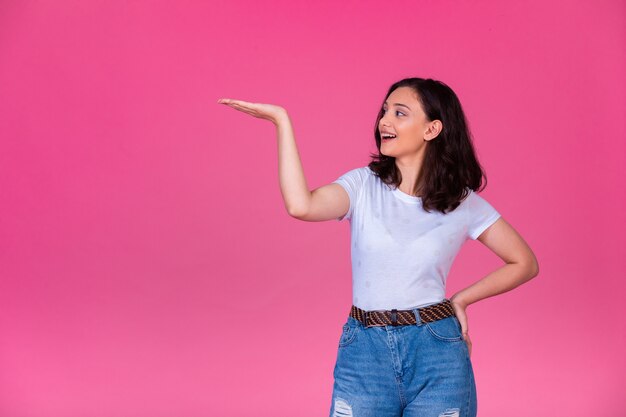 Young girl opens hand and introduces something while smiling