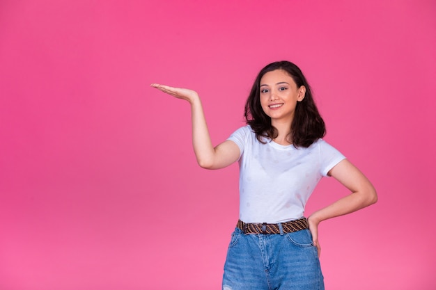 Young girl opens hand and introduces something. 