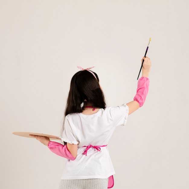 Молодая девушка рисует вид сзади