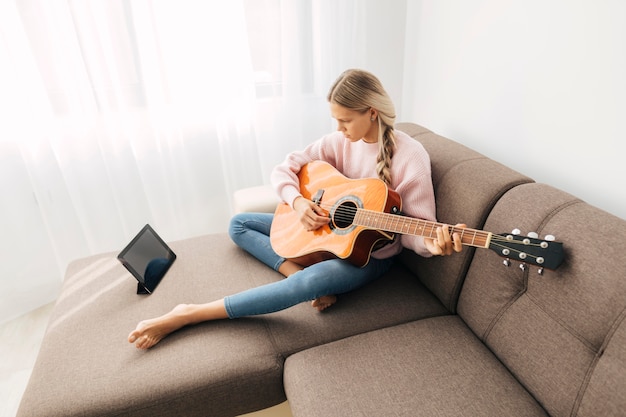 Foto gratuita ragazza che gioca una chitarra a casa