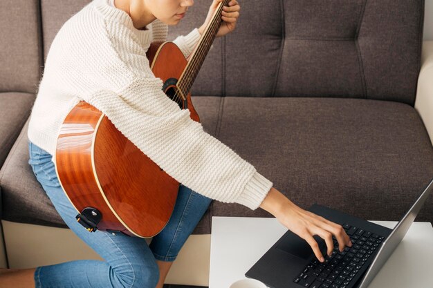 Young girl playing a guitar at home