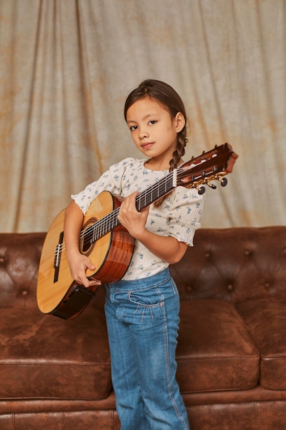 Young girl playing guitar at home