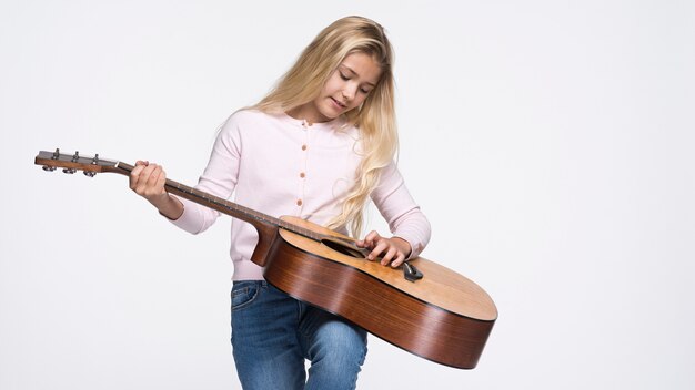 Young girl playing at guitar