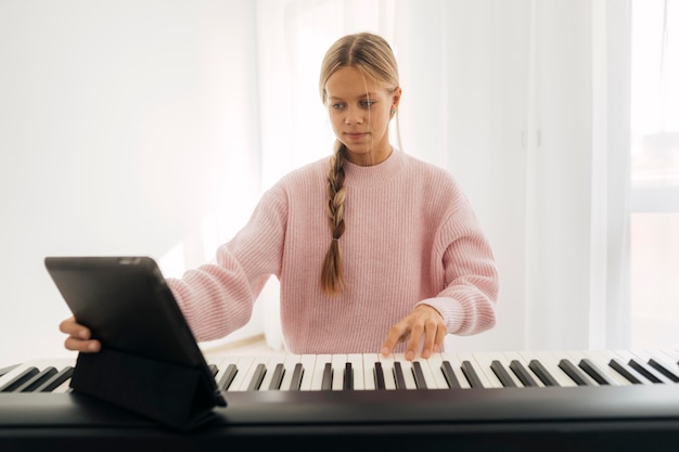 Young girl playing keyboard instrument at home