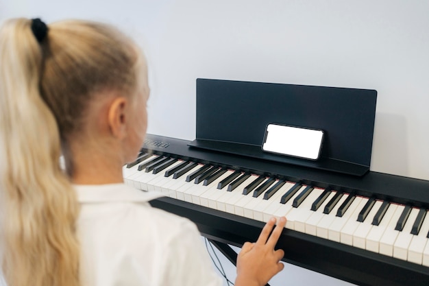Молодая девушка играет на клавишном инструменте