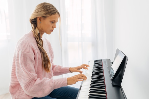 Бесплатное фото Молодая девушка играет на клавишном инструменте