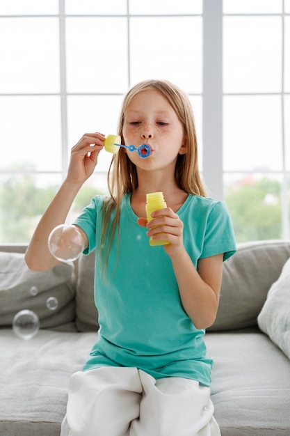 Free photo young girl playing with soap bubbles