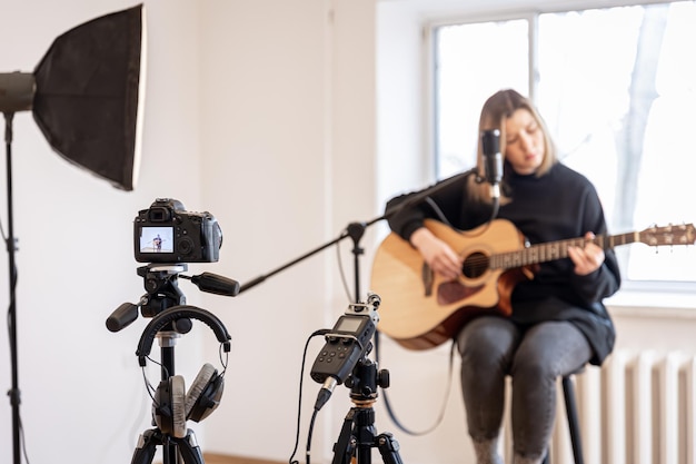 A young girl plays the guitar recording video and sound