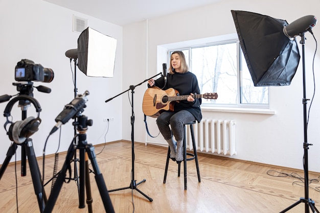 A young girl plays the guitar recording video and sound