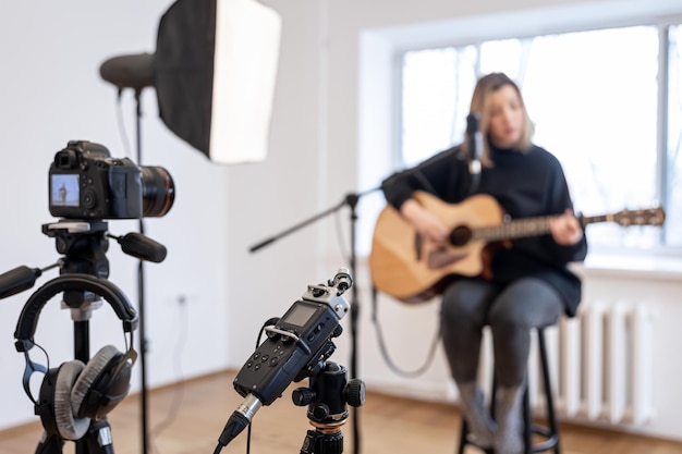 A young girl plays the guitar recording video and sound