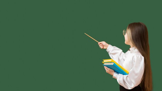 Young girl pointing at blackboard