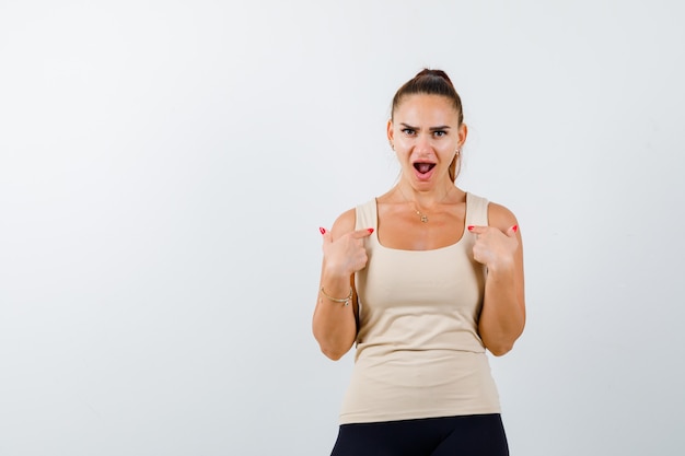 Free photo young girl pointing at herself with index fingers in beige top