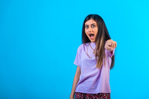 Young girl pointing at something with finger gest.