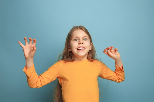 Young girl posing against blue wall