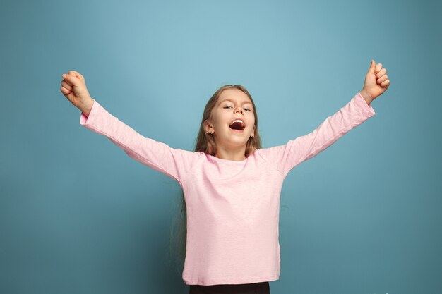 Young girl posing against blue wall