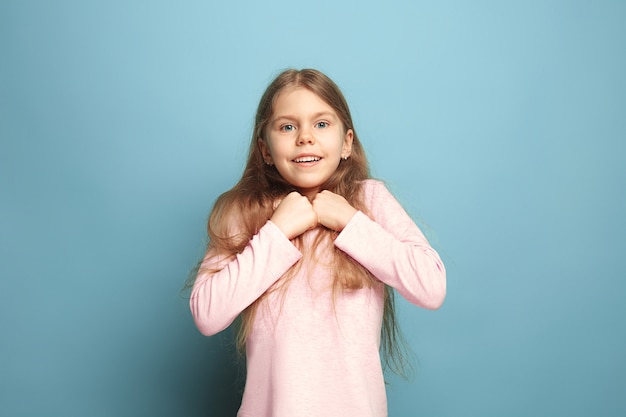 Young girl posing against blue wall