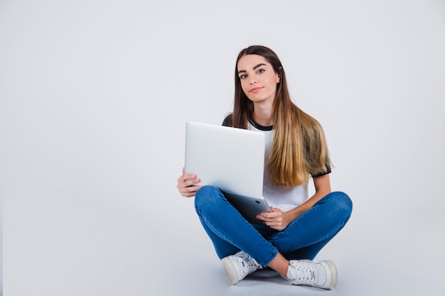 Free photo young girl posing on the floor with lap top