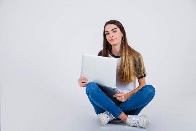 Young girl posing on the floor with lap top