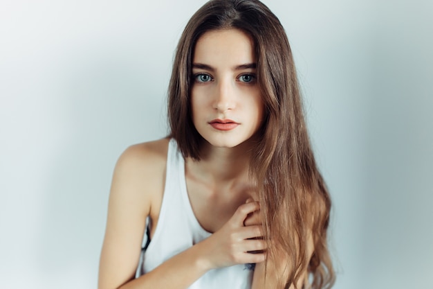 Free photo young girl posing in front of the camera on a white background