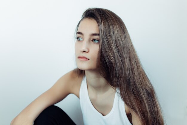 Young girl posing in front of the camera on a white background