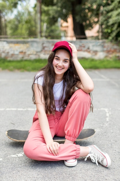 Free photo young girl posing on her skateboard