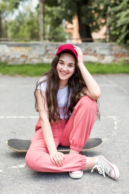 Молодая девушка позирует на своем скейтборде