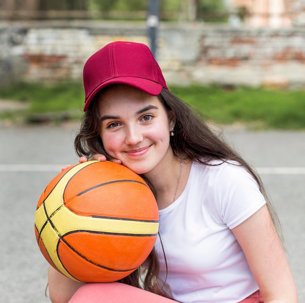 Free photo young girl posing with a basketball