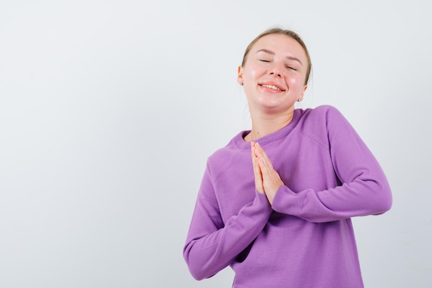 Young girl praying on white background