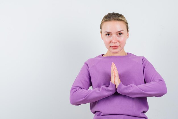 Young girl praying on white background