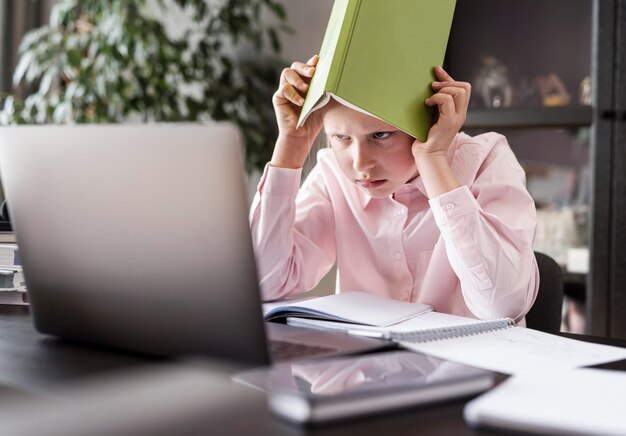 Young girl putting a book on her head