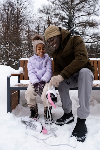 Young girl putting on her ice skates outdoors in winter