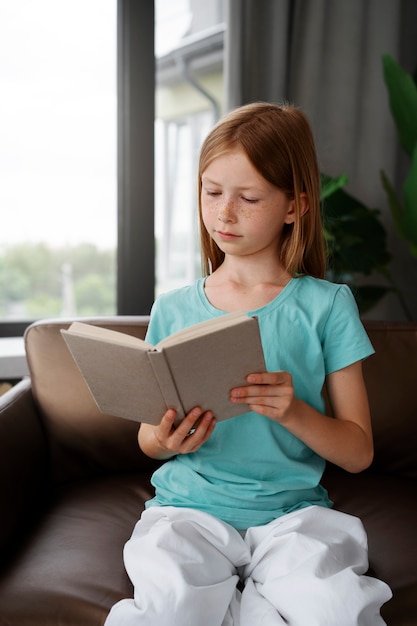 Free photo young girl reading a book