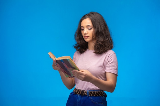 Young girl reading an old book and looks serious